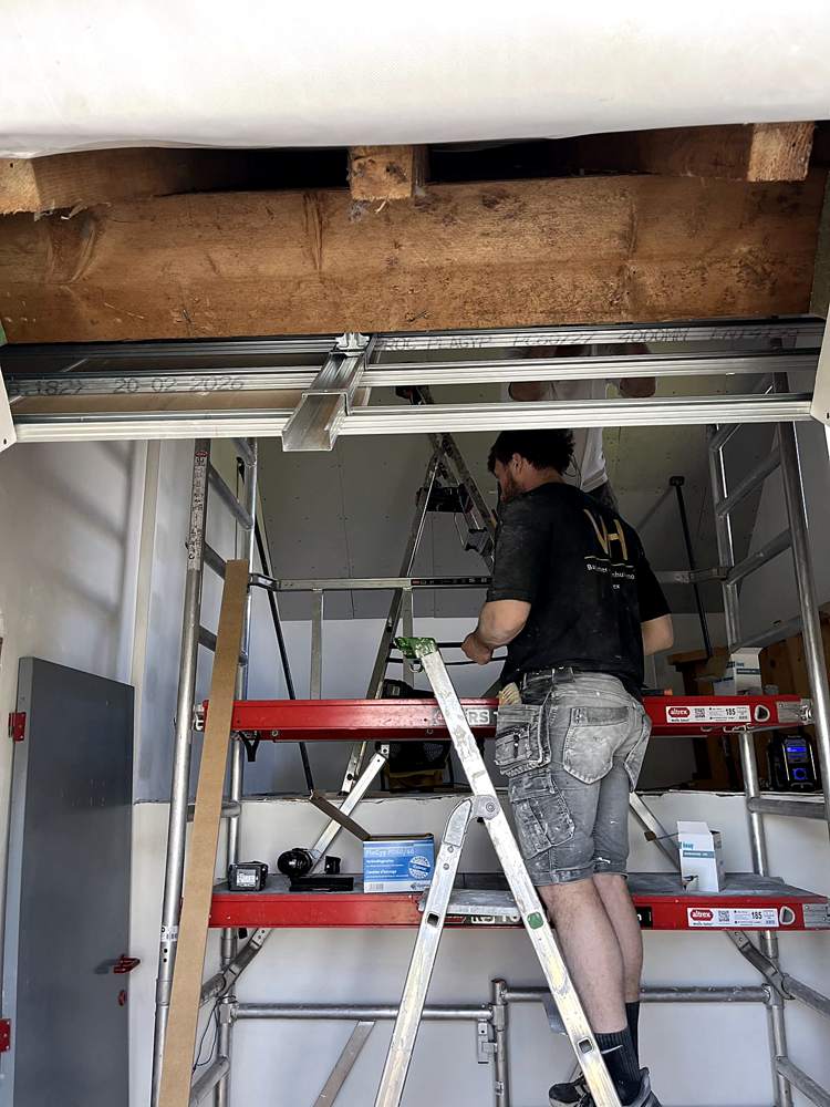 Vakman op de stelling onder de dakconstructie