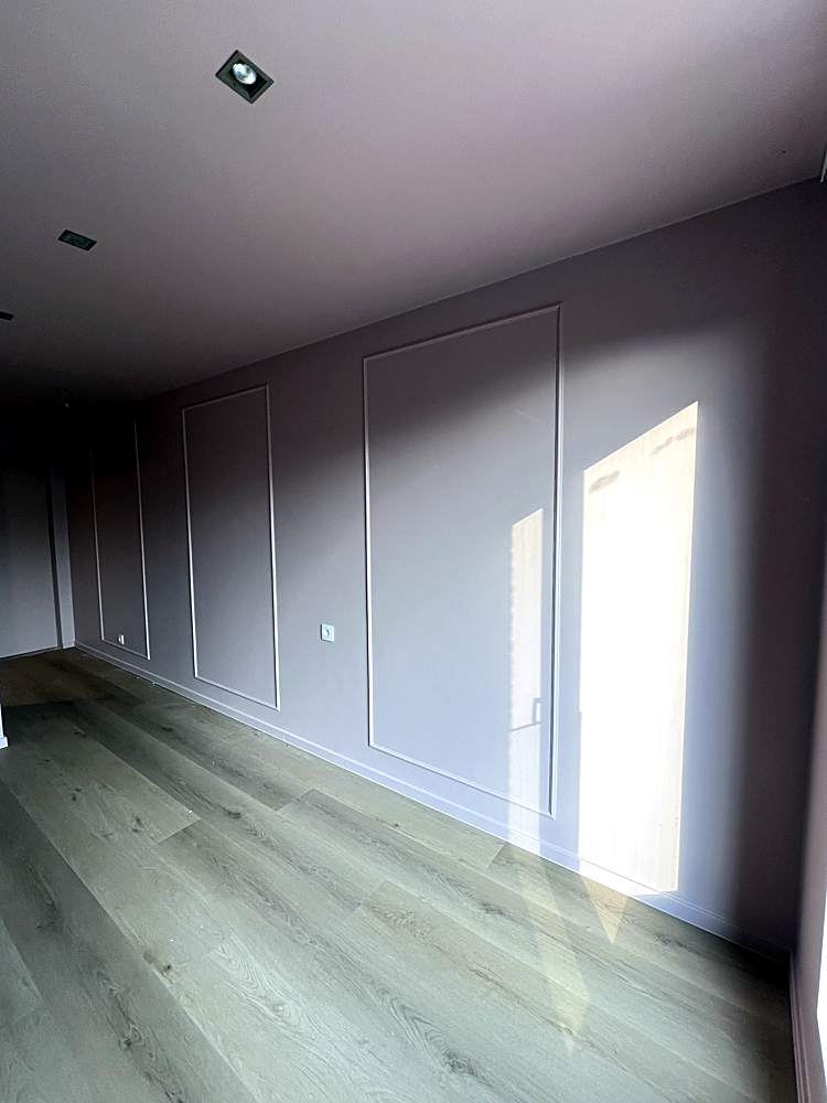 Slaapkamer met geschilderde lambrisering en parket