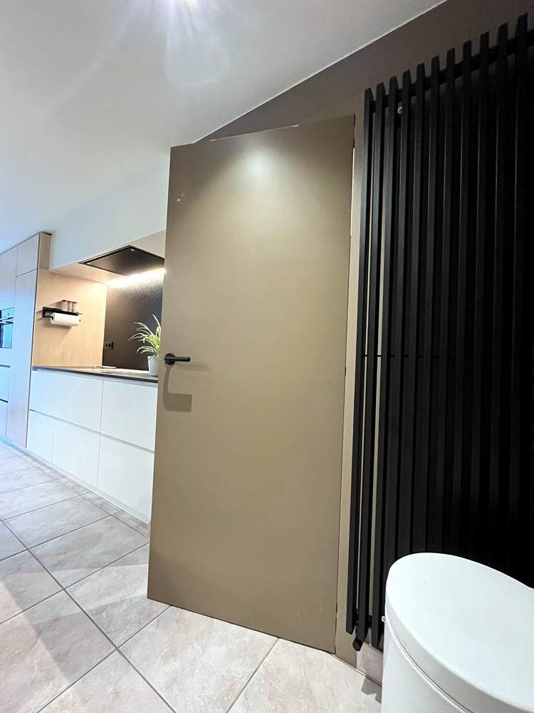 Hal met taupe deur en zwarte radiator